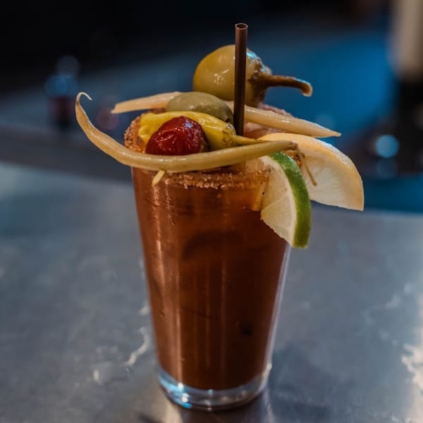 A Bloody Mary cocktail from 5 Spot, garnished with olives, peppers, and citrus slices.